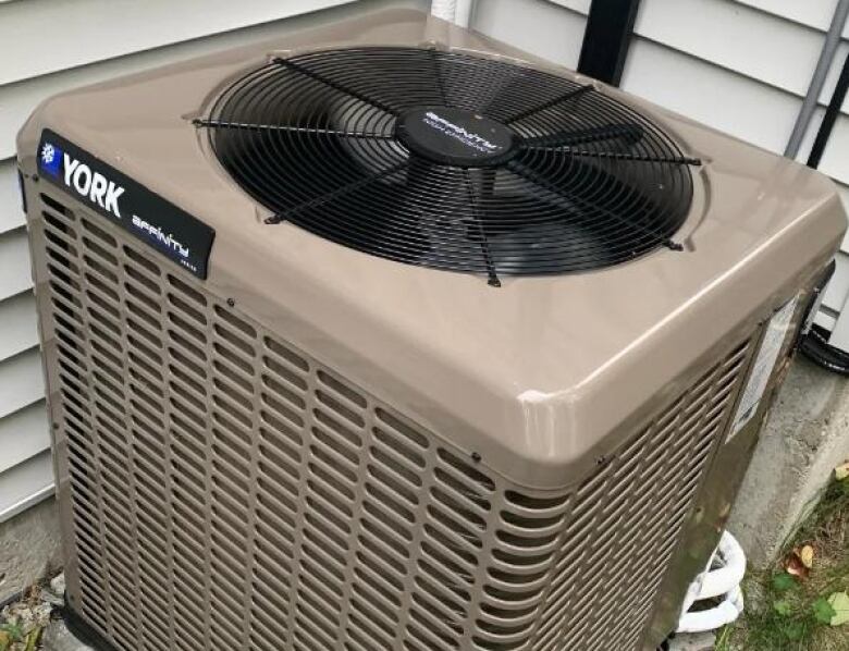 A light-brown coloured heat pump is pictured outside a home.