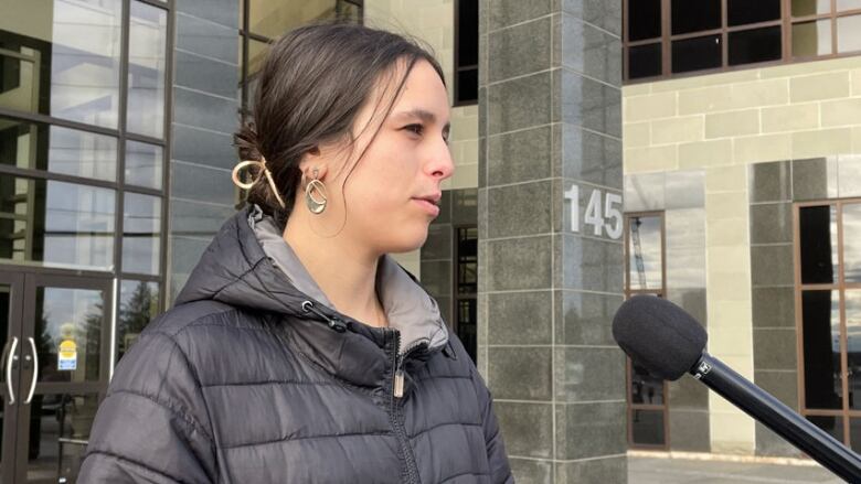 A portrait of a young woman outside the Moncton courthouse.