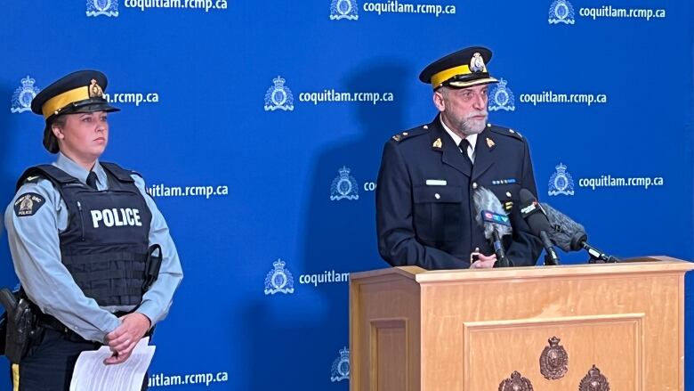 Two police officers stand at a podium.