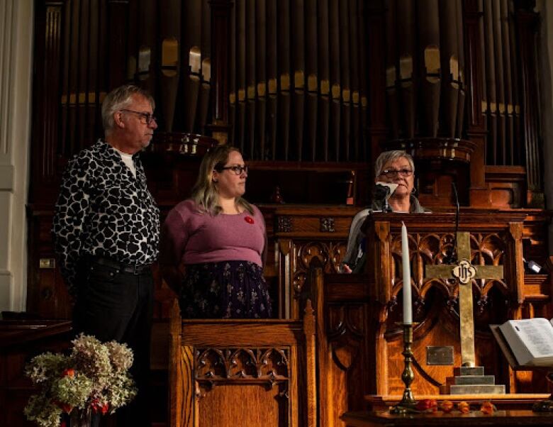 People are standing in a church. 