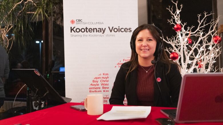 Corey, a woman wearing a headset, smiles in front of a CBC banner.