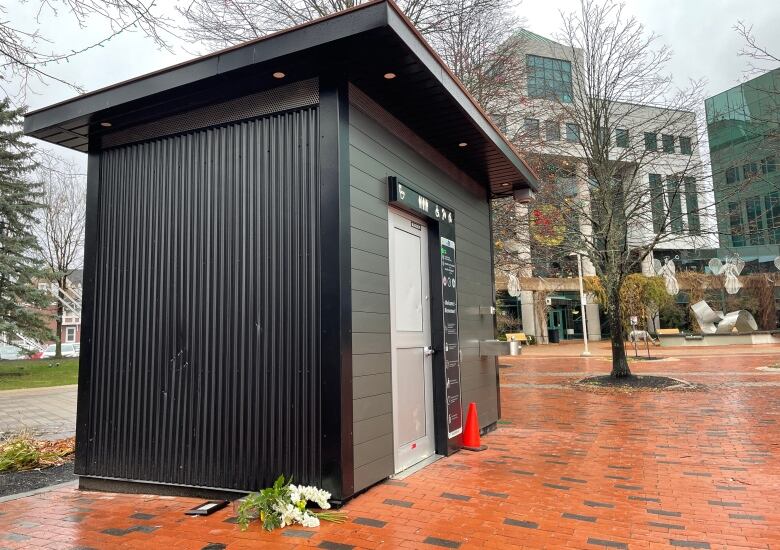 Flowers and a note that reads in part, 'A man died here because there was no room at the inn. It's time to end homelessness,' have been placed outside the public washroom when 35-year-old Luke Landry was found dead last week.