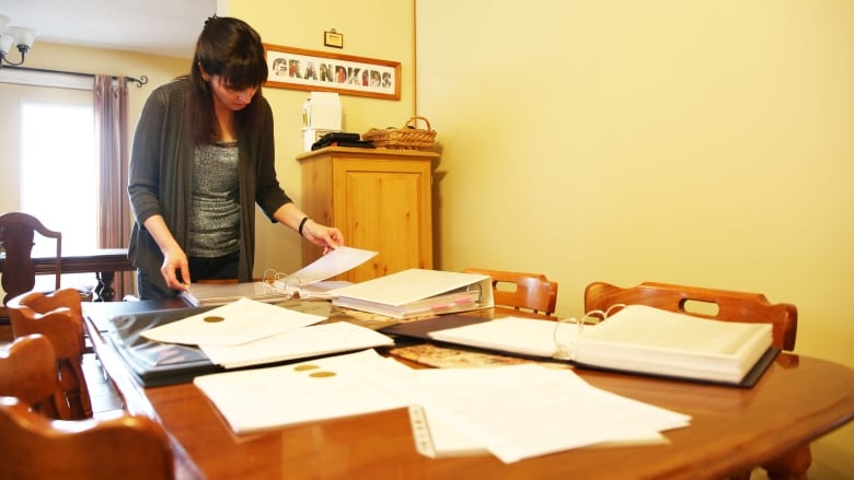 A woman goes through binders and folders.