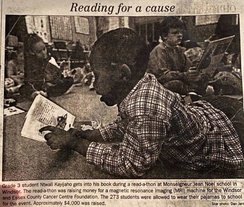 A newspaper clipping of a boy wearing pajamas and reading a book.