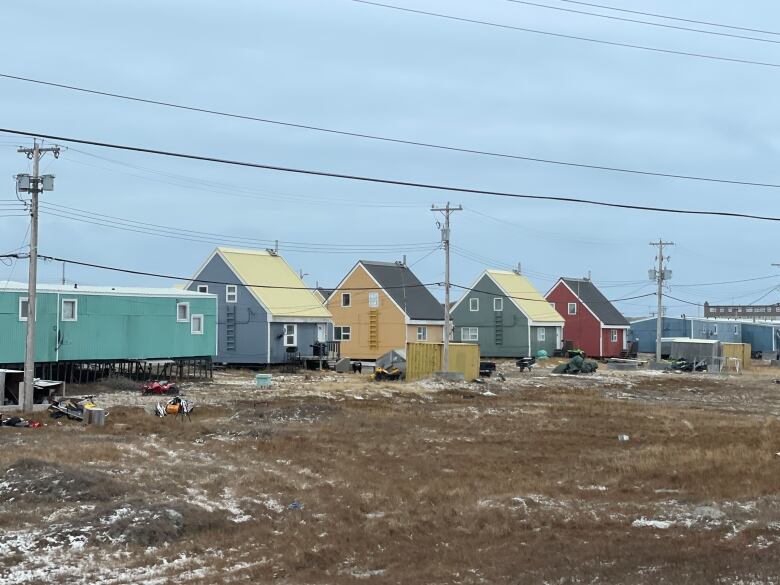 A row of colourful houses with low-hanging roofs on the streets of Rankin Inlet 