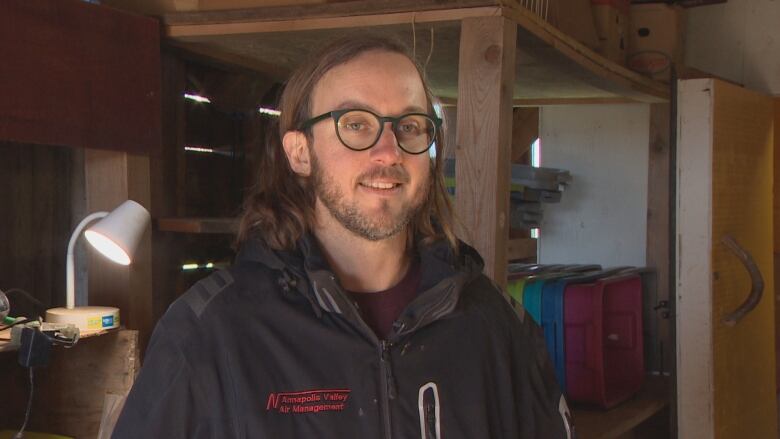 Portrait of a man standing in a wooden barn.