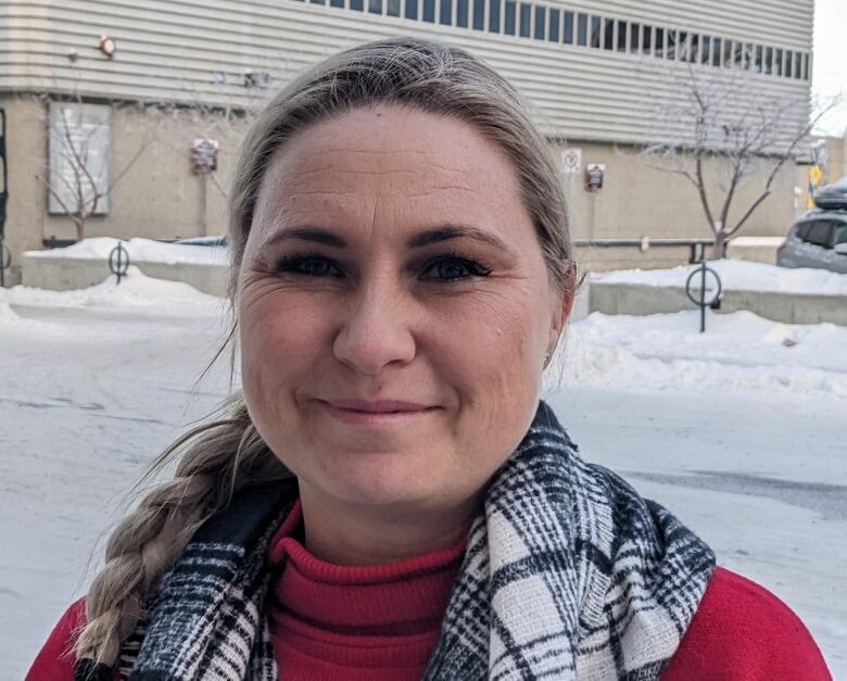 A portrait of a woman smiling on a snowy street.