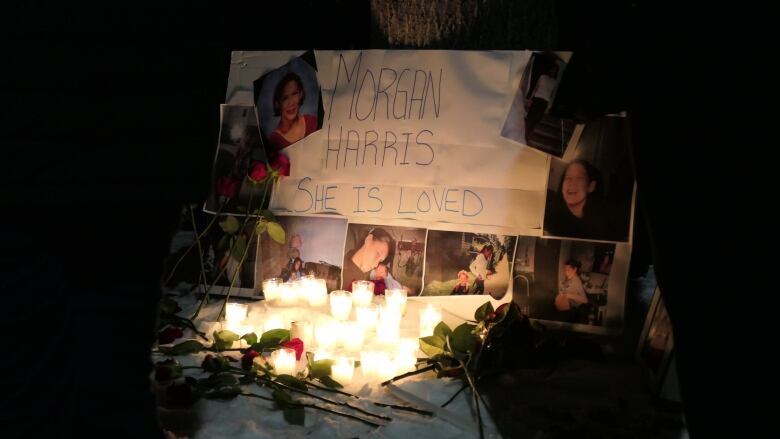 Candles stand beside a homemade sign saying 