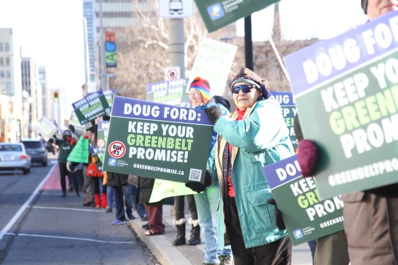 Protesters held both handmade and printed signs with pictures and messages to stop Bill 23.