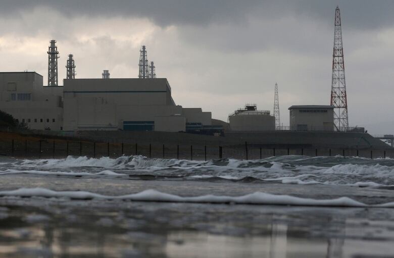 A power plant is shown next to a body of water.