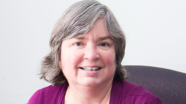 A woman in a purple blouse.