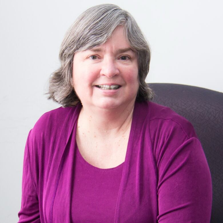 A woman in a purple blouse.