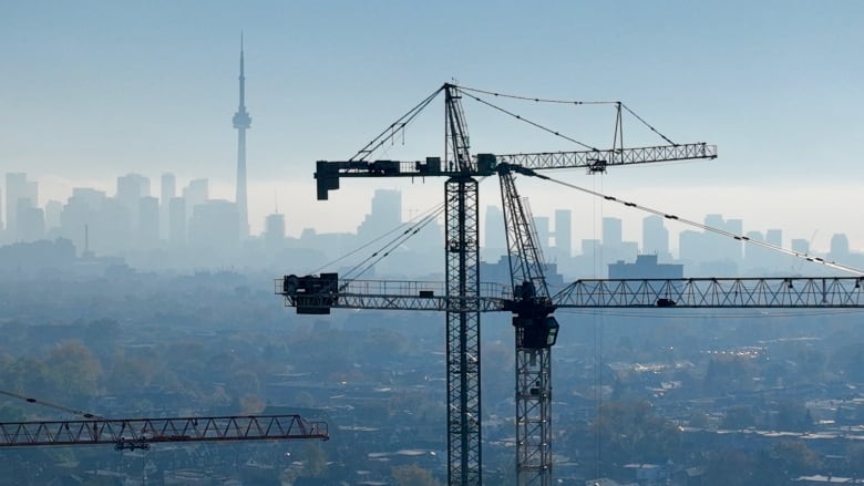 Cranes in the foreground with Toronto's skyline in the background. 