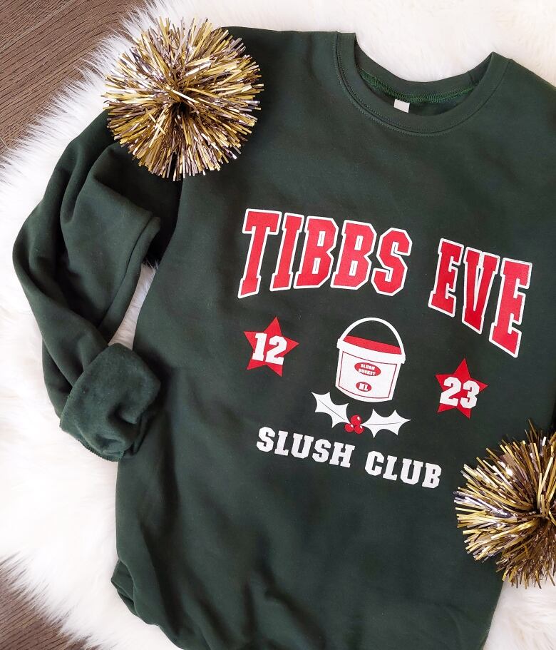 A dark green sweatshirt with the words Tibbs Eve Slush Club and a picture of a salt beef bucket.