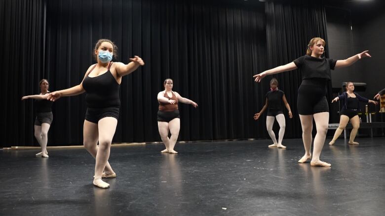 A group of dancers spin on a stage. 