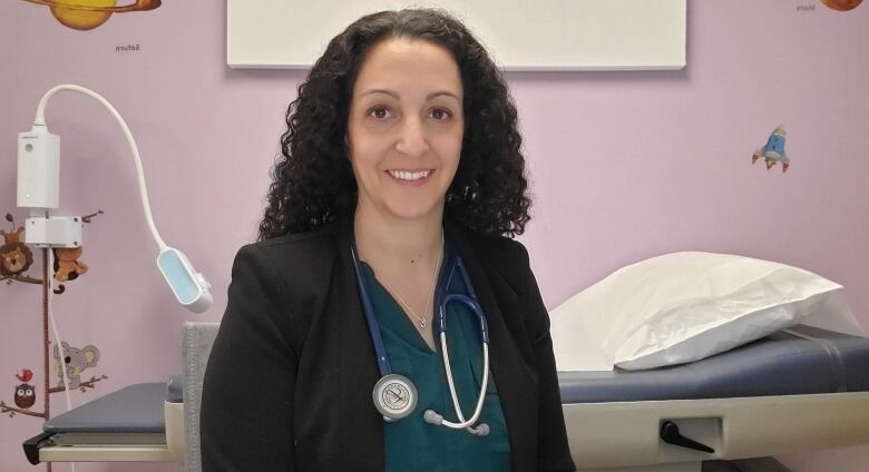 Dr. Amber Miners sits in a medical examination room.