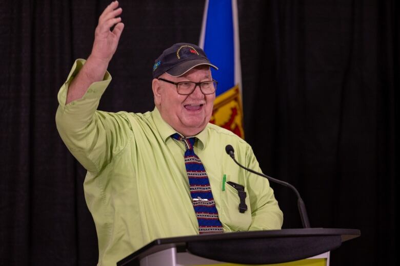 A man smiles at a podium