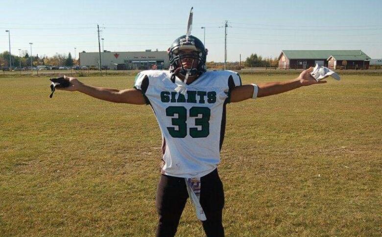 Tyree Cayer shows off his Elmwood Giants uniform in his high school football-playing days.