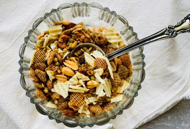 A bowl of snack mix sits on a kitchen table.