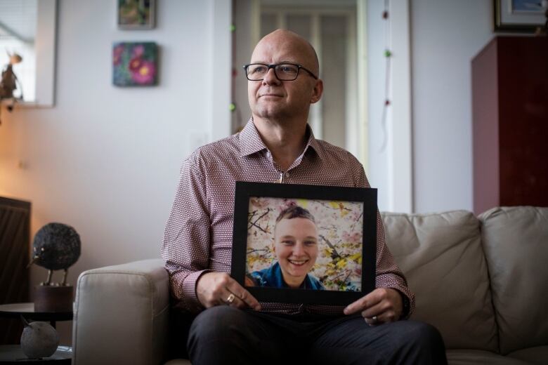 Dennis Cooper is pictured holding a picture of his child who was shot and killed by police in November in North Vancouver, British Columbia on Tuesday December 13, 2022. 