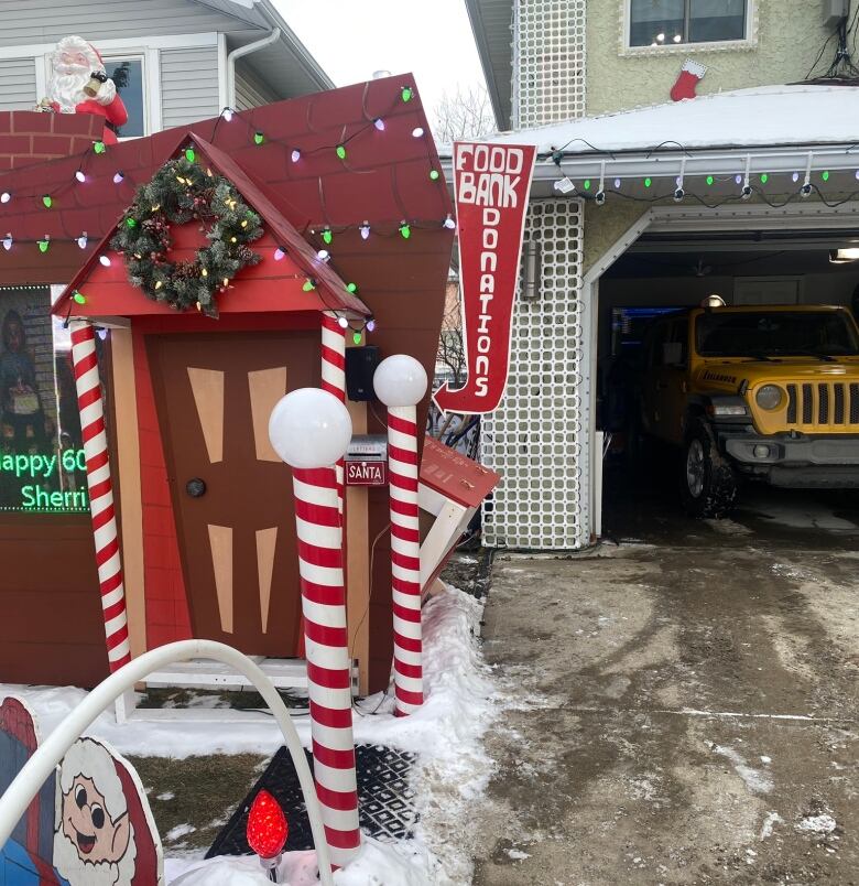 A wooden house covered in lights sits off to the side of a driveway. 