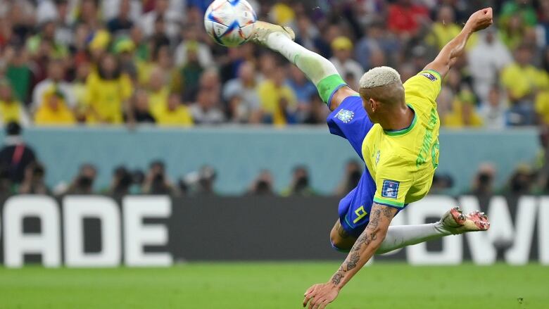 A man jumps to kick soccer ball.