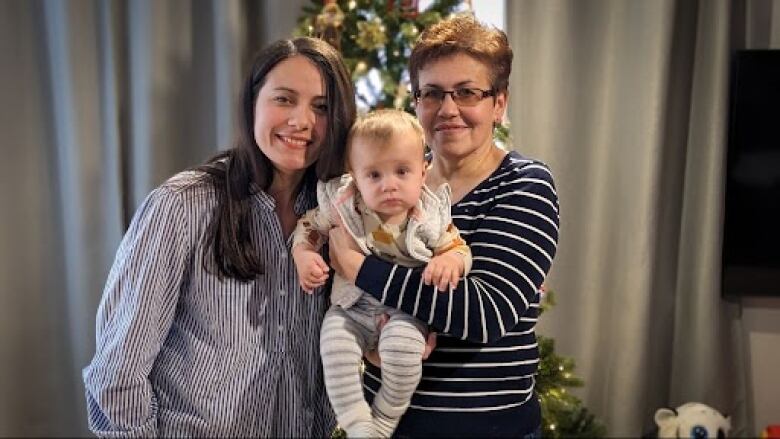 Elina Lialiuk stands with her mother, who is holding baby Nicole. 