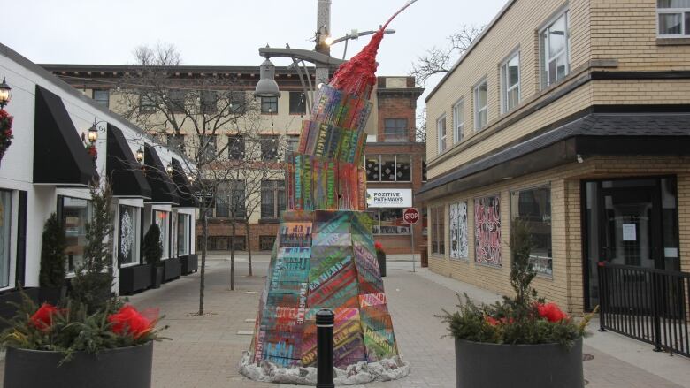 Colourful pieces of wood are stacked up tall into a mountain like structure.