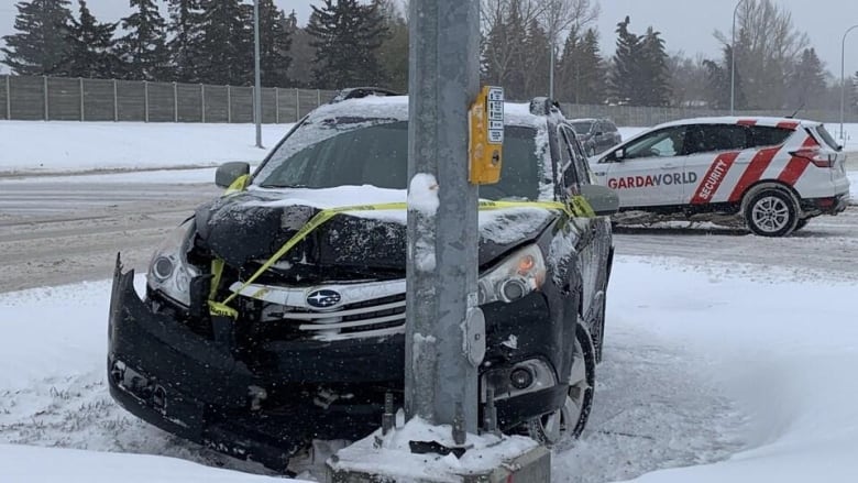 An SUV crashed into a vehicle with a piece of police tape on it. There is snow on the ground and a Gardaworld SUV in the background.