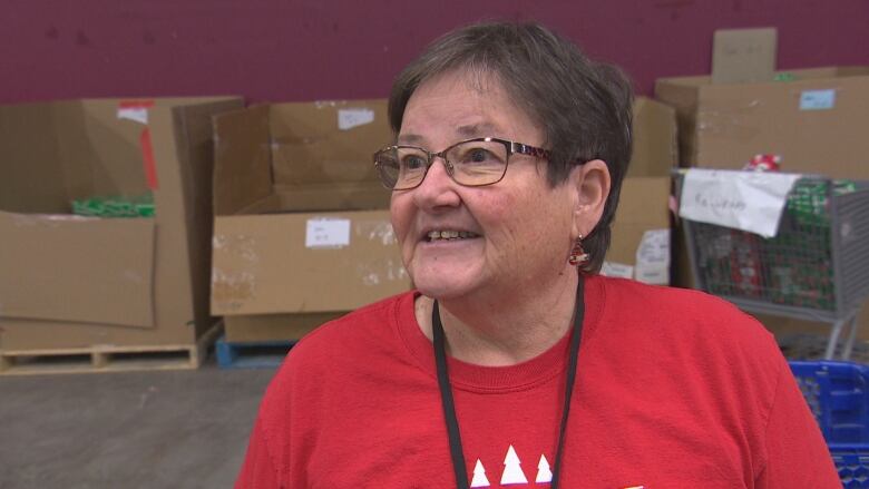 A woman is surrounded by big box bins.