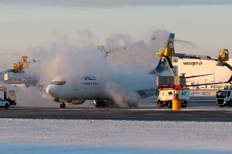 A passenger plane is being de-iced at an airport. 