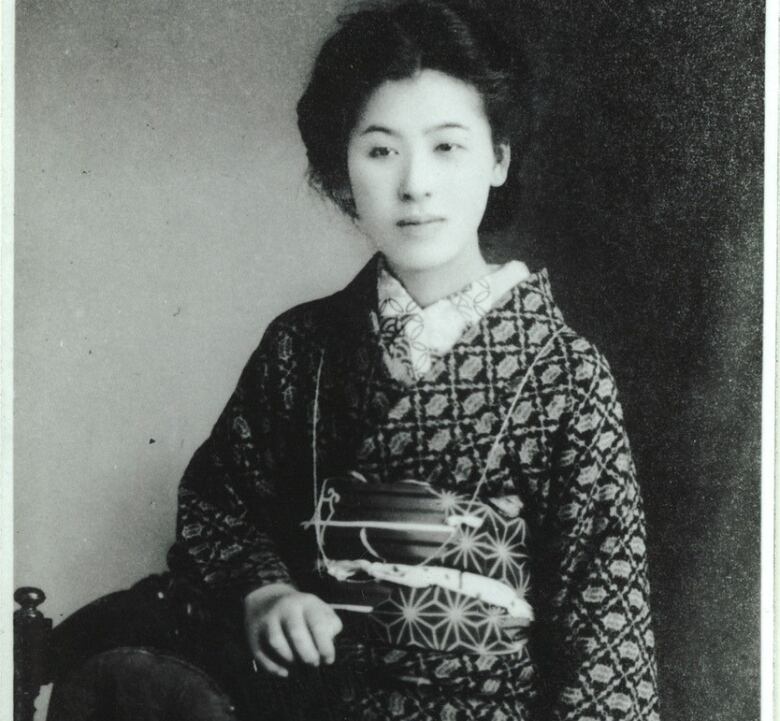 A black-and-white portrait of a woman wearing a kimono. 