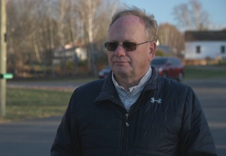 A man stands in a parking lot.