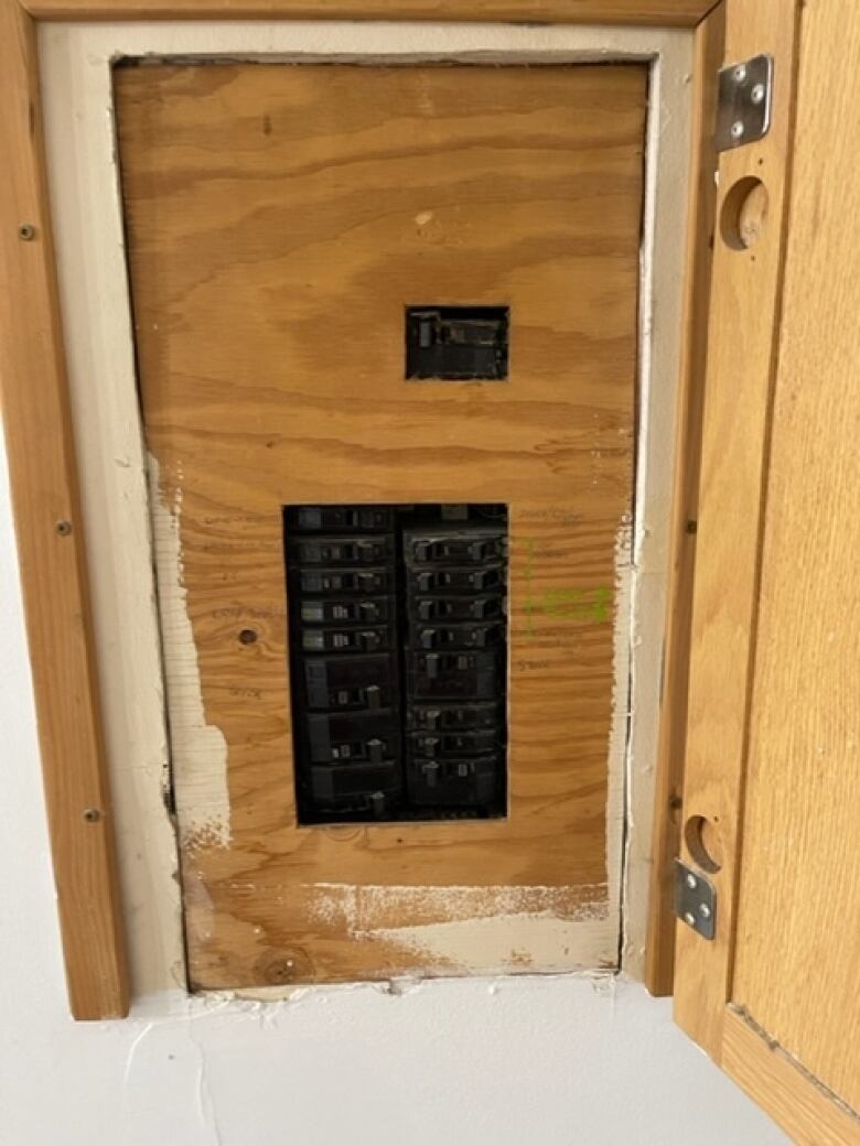 An electric panel surrounded by plywood.