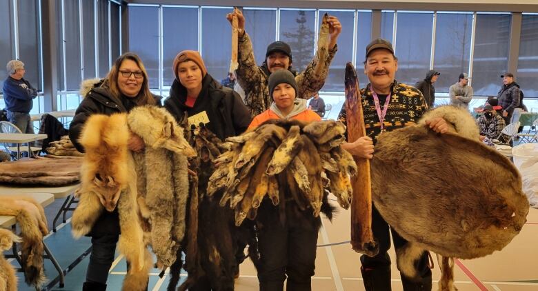 Numerous furs of Martens, beavers, and other animals are shown off by a family at the Thompson Fur Table