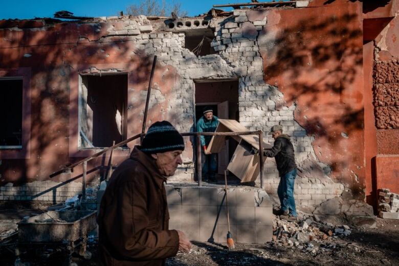 Workers carry furniture from a damaged hospital in Kherson, southern Ukraine. 