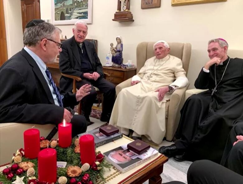 Former pope Benedict meets with a scholar and two church officials.