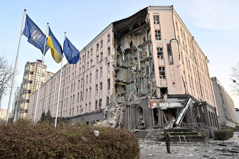 A building is seen partially destroyed by a missile strike.