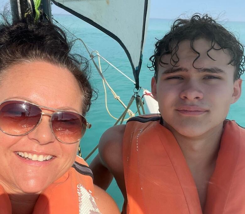 A woman and her son in orange life safety vests.