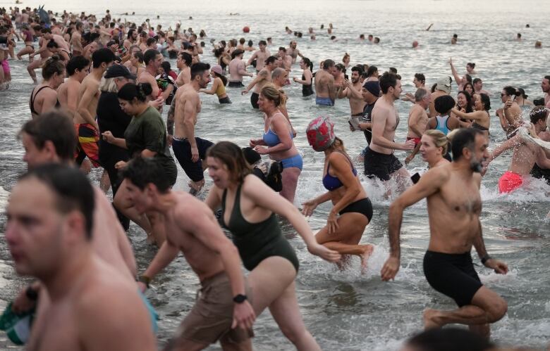 People wearing bathing suits take part in a Polar Bear Swim in Vancouver on New Year's Day.