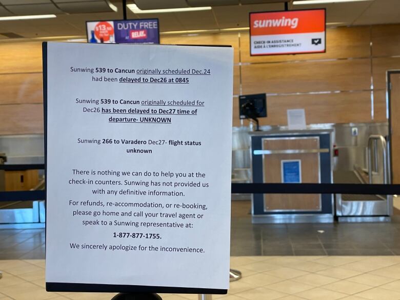 Sign at sunwing kiosk at Regina airport showing lists of flights cancelled.