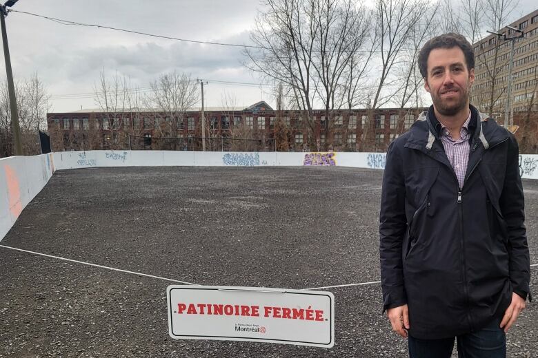 Man standing in front of ice rink with no ice