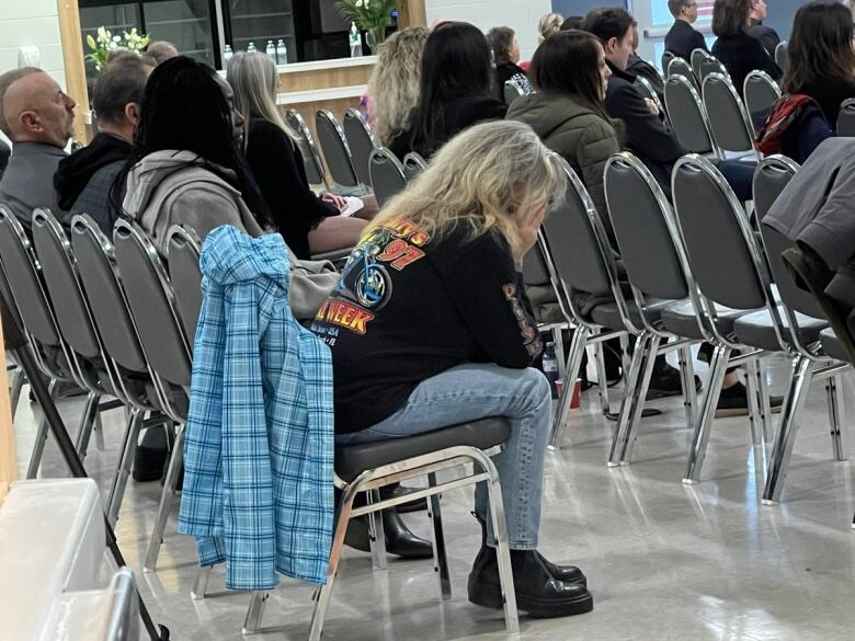 A person sits with their face in their hands. 