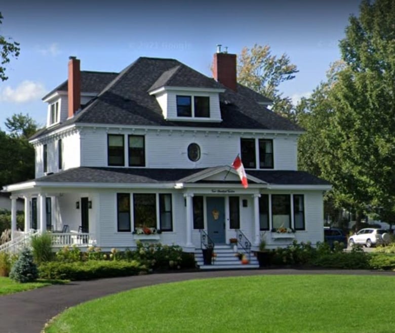 A photo of a large, white three-storey home.