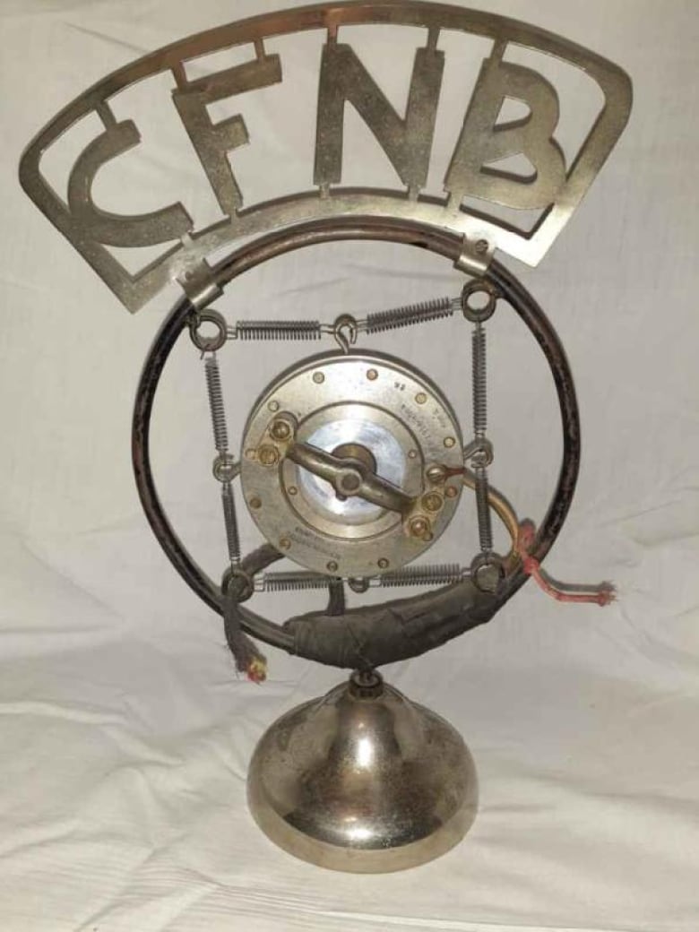 An old fashioned radio microphone with the CFNB logo on top.