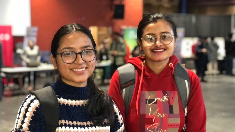 Two college students wearing backpacks.