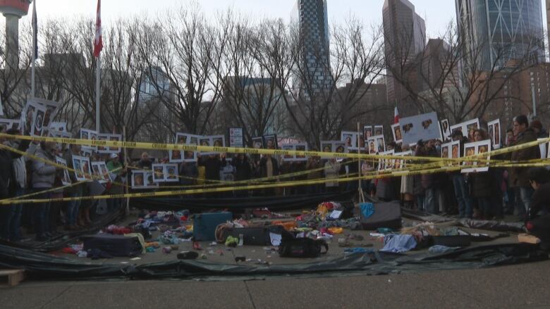 Bags are scattered on the ground with yellow tape around them.