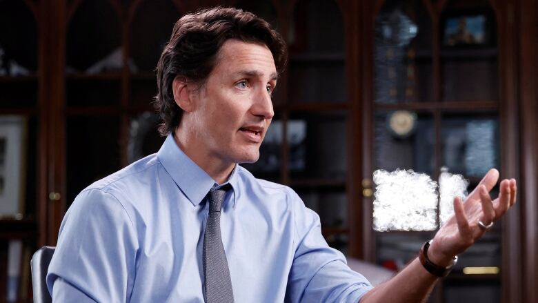 A politician gestures with an open hand during a sit-down interview.