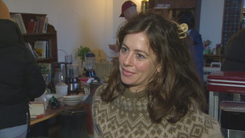 Elizabeth Bryan, restaurant owner, is photographed up close. She is a white woman about 40-years-old with brown hair and wears a Scandinavian-style sweater.