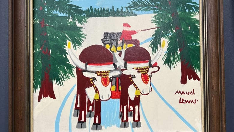 A framed painting by Maud Lewis of two oxen hauling a load of lumber through the snowy woods.